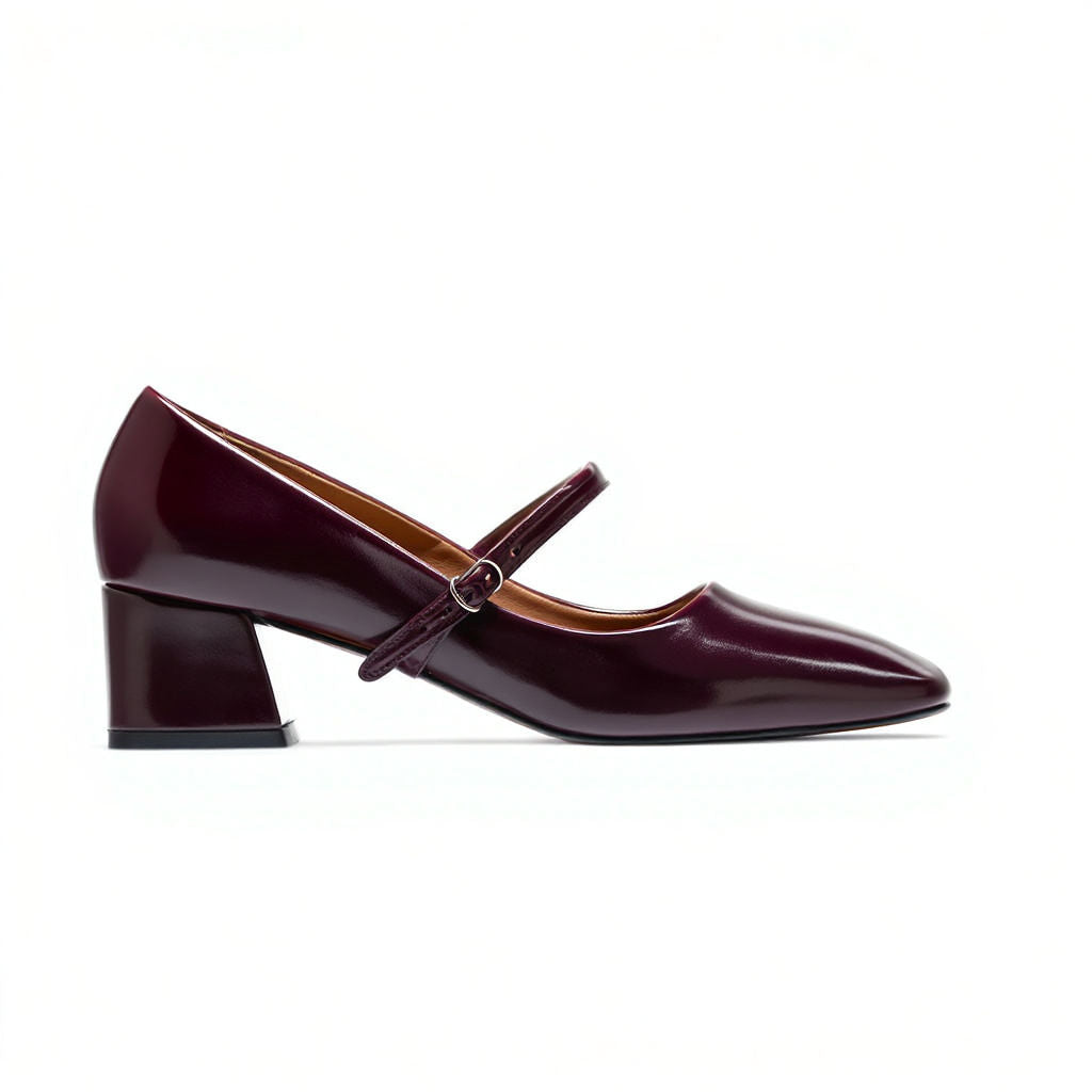 Maroon patent leather shoe with a strap on a white background