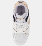 White sneaker with gold accents and 'Guess' branding on a white background