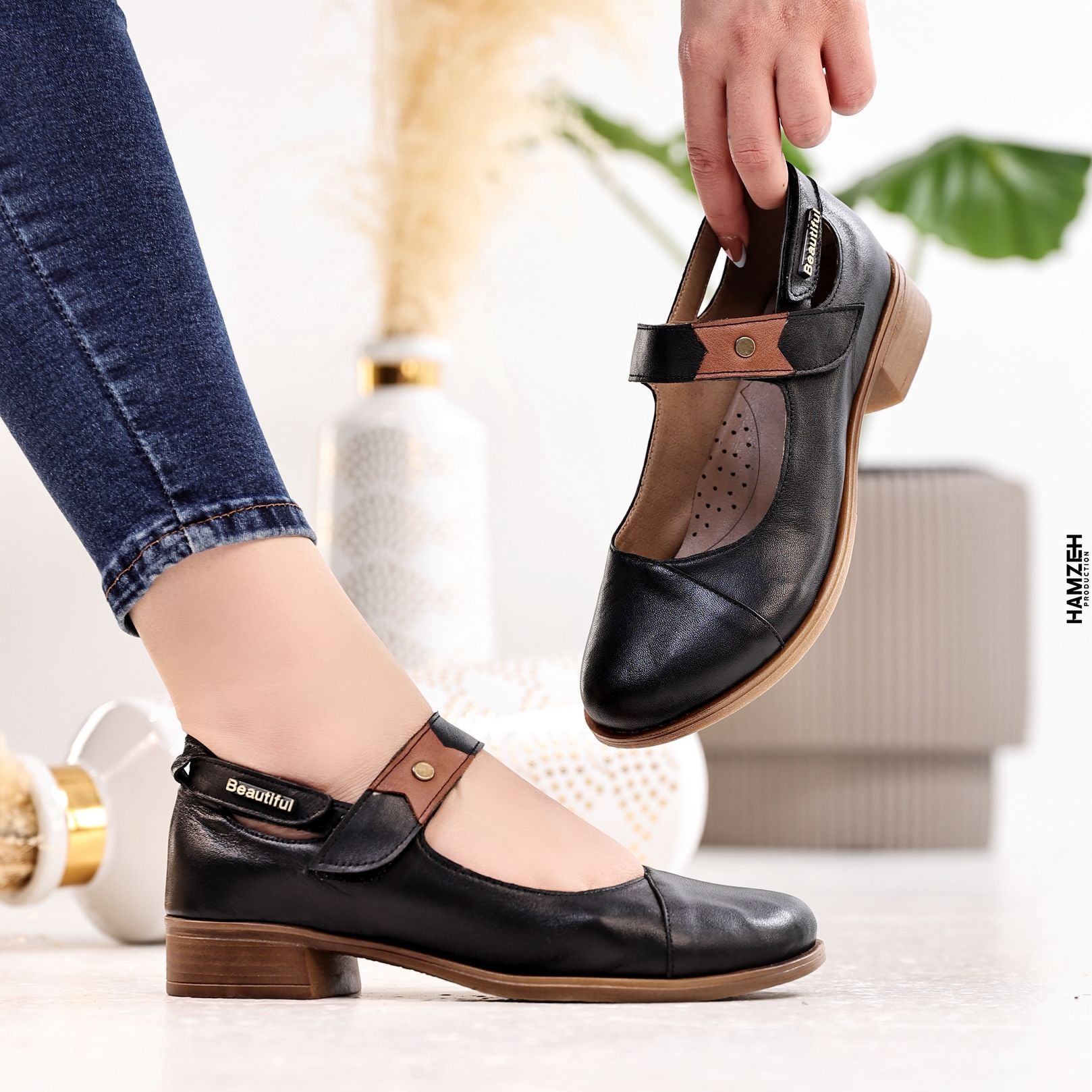 Black shoes with brown accents worn by a person, with 'B Beautiful Comfort' branding.