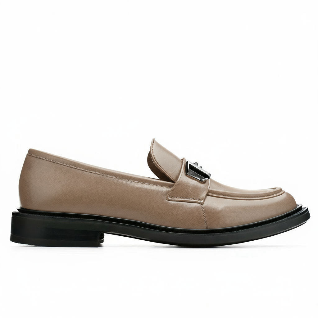 Beige loafer with black sole on a white background