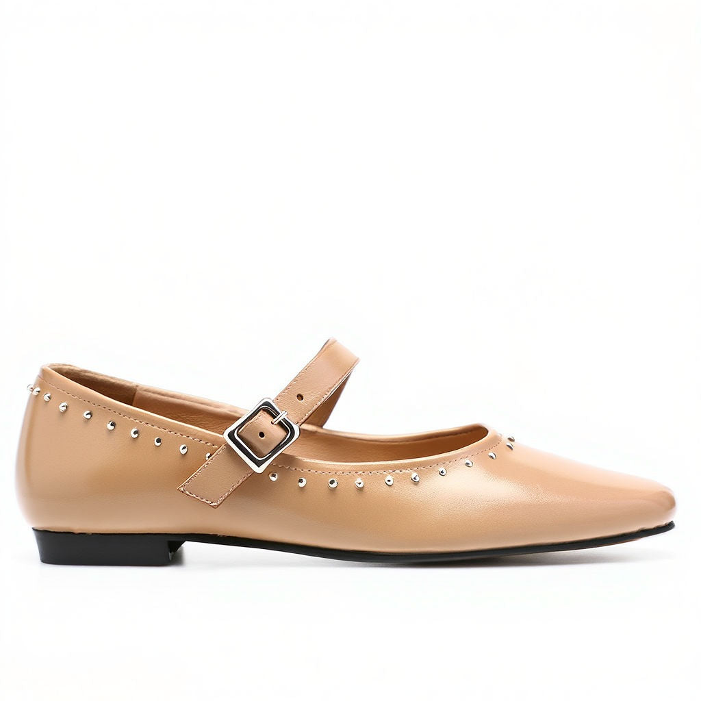 Beige flat shoe with a buckle on a white background
