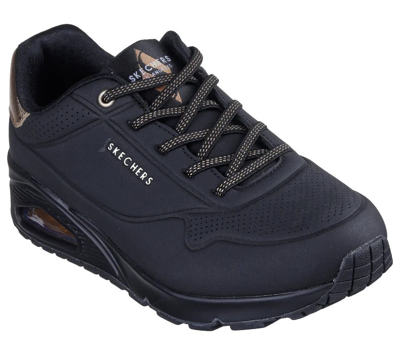 Angled view of Skechers Uno Shimmer Away black women’s sneakers showing sleek design and air-cushioned sole.
