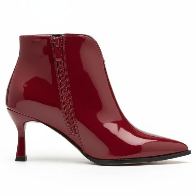 Red patent leather ankle boot with a zipper on a white background