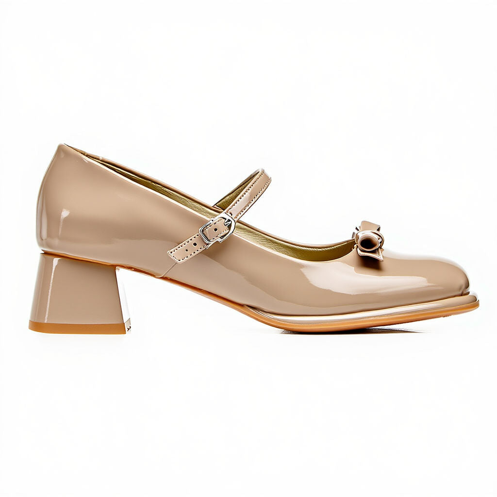 Beige patent leather shoe with a strap and small bow on a white background