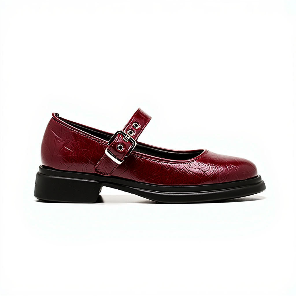 Maroon shoe with a strap and buckle on a white background